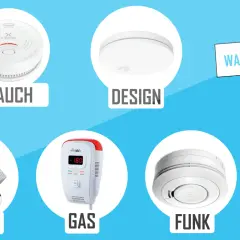Rauch-, Wasser-, Gas- und Funkwarnmelder im Test. Ein Handwerker hält ein Schild mit der Aufschrift "Warnmelder".