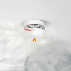 Ein **Genius Plus Rauchmelder piept** und warnt vor Rauch und einer kleinen Flamme.