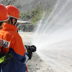 Zwei Feuerwehrleute üben mit einem Schlauch, wie im Feuerwehrgesetz Niedersachsen vorgeschrieben.