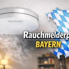 Rauchmelderpflicht in Bayern: Ein Rauchmelder an der Decke warnt vor Brandgefahr. Die bayerische Landeskarte im Rautenmuster symbolisiert die Pflicht.