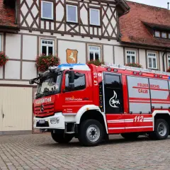 Rotes Löschfahrzeug LF 10 der Feuerwehr Calw, Abteilung Hirsau, vor einem Fachwerkhaus. Das Fahrzeug entspricht der DIN 14530-5.
