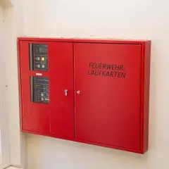 Rote Box mit der Aufschrift "FEUERWEHR-LAUFKARTEN" und Bedienfeldern für die Feuerwehr.