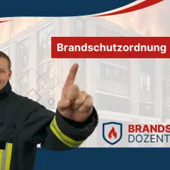 Brandschutzordnung Hamburg: Feuerwehrmann erklärt wichtige Regeln. Im Hintergrund brennendes Gebäude.