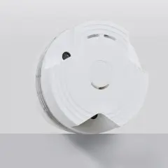 Ein weißer Rauchmelder, der auf einer grauen Fläche schwebt. Hier erfahren Sie, wie Sie einen Techem Rauchmelder ausschalten.