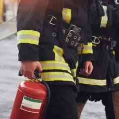 Feuerwehrleute mit Feuerlöscher und Schlauch. Informationen zu den berufsfeuerwehr voraussetzungen.