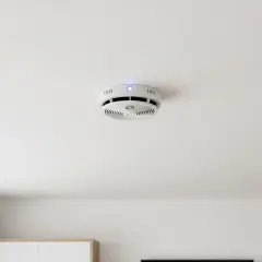 Rauchmelder an der Decke mit blauem Licht. Ein Fehlalarm durch zu hohe Luftfeuchtigkeit ist möglich.