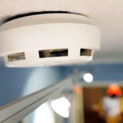 Ein weißer Rauchmelder an der Decke, wichtig für Mieter und Vermieter zur Sicherheit.