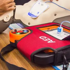 Defi-Herz-Training: Ein AED-Gerät und eine Übungspuppe für lebensrettende Maßnahmen.