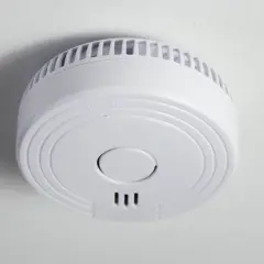 Ein weißer Funkrauchmelder an der Decke. Mögliche Nachteile von Funkrauchmeldern sind die Abhängigkeit von Batterien und Funkstörungen.