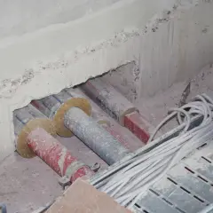 Rohre und Kabel werden für den Brandschutz auf Baustellen vorbereitet. Isolierte Rohre und Kabelbündel liegen bereit.