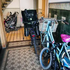 Zwei Fahrräder und Kinderwagen im Treppenhaus. Was darf im Treppenhaus stehen? Hier ist ein Beispiel, das zeigt, was man verstauen kann.