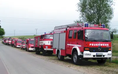 Reihe von roten Feuerwehrfahrzeugen, darunter 9 Fahrzeugtypen der Feuerwehr, bereit für den Einsatz.