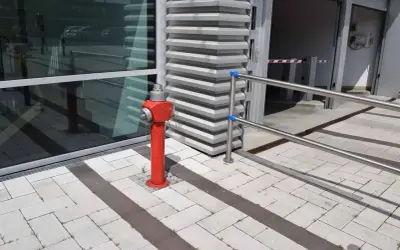 Ein roter hydrant steht auf einem gepflasterten Weg. Er ist bereit, im Notfall eine hohe hydrant durchflussmenge zu liefern.