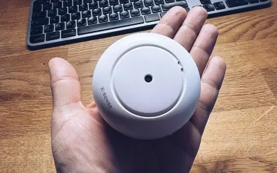 Rauchmelder von X-Sense in der Hand, bereit für die Integration in Home Assistant.