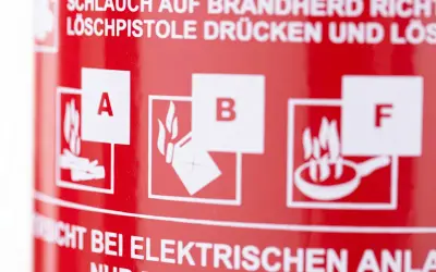 Symbole für Brandklasse A, B und F auf rotem Feuerlöscher. Wichtige Hinweise zur Brandbekämpfung.