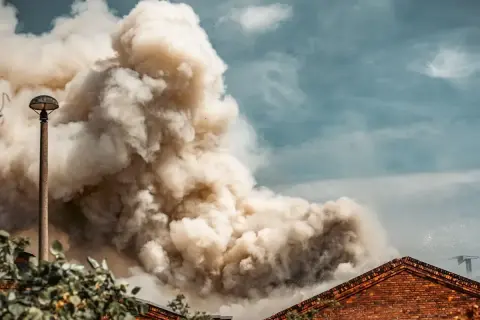 Dichter Rauch steigt aus einem Gebäude auf, ein Zeichen für eine laufende mechanische entrauchung.