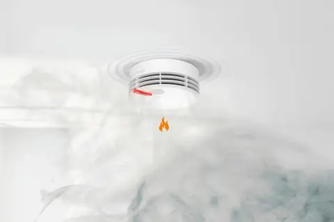 Ein **Genius Plus Rauchmelder piept** und warnt vor Rauch und einer kleinen Flamme.