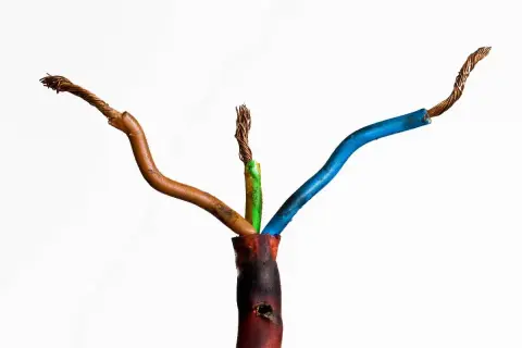 Beschädigte Kabel mit freiliegenden Drähten, die auf einen möglichen kabelbrand geruch hindeuten. Die Isolierung ist an einer Stelle geschmolzen.