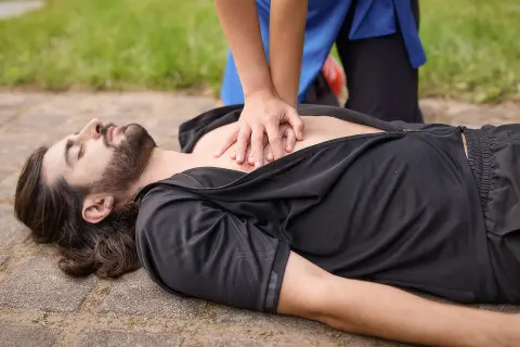 Hände auf die Mitte des Brustkorbs legen und kräftig drücken. So geht Herzdruckmassage, um Leben zu retten.