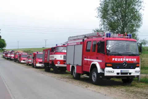 Reihe von roten Feuerwehrfahrzeugen, darunter 9 Fahrzeugtypen der Feuerwehr, bereit für den Einsatz.