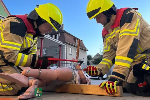 Zwei Feuerwehrleute üben mit einer Übungspuppe. Tolle Feuerwehr Übungen Ideen für realistische Szenarien.