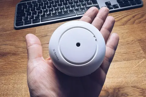 Rauchmelder von X-Sense in der Hand, bereit für die Integration in Home Assistant.
