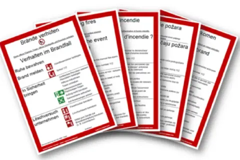 Mehrsprachige Brandschutzordnungen, die die Pflicht zur Brandverhütung und das Verhalten im Brandfall erklären.