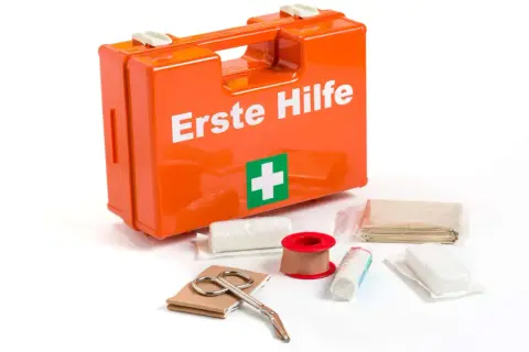 Erste-Hilfe-Kasten mit Verbandszeug, Schere und Pflasterrolle. Wichtig für jeden Ersthelfer und Brandschutzhelfer.