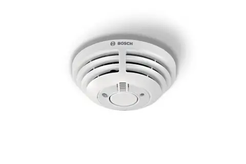 Ein weißer Bosch Smart Home Rauchmelder blinkt rot, was auf eine mögliche Gefahr hinweist.