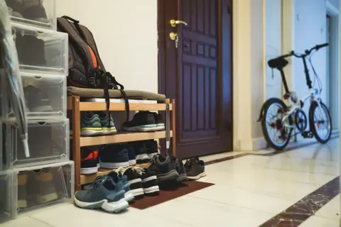 Schuhregal, Rucksack, Regenschirm und ein Klapprad – so darf es im Hausflur stehen.