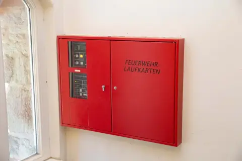 Rote Box mit der Aufschrift "FEUERWEHR-LAUFKARTEN" und Bedienfeldern für die Feuerwehr.