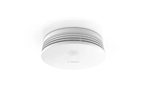 Ein weißer Rauchmelder von Bosch, der an der Decke montiert ist. Er zeigt das Bosch-Logo und eine Lautsprecheröffnung. Hier erfahren Sie, wie Sie die Bosch TwinGuard Batterie wechseln.
