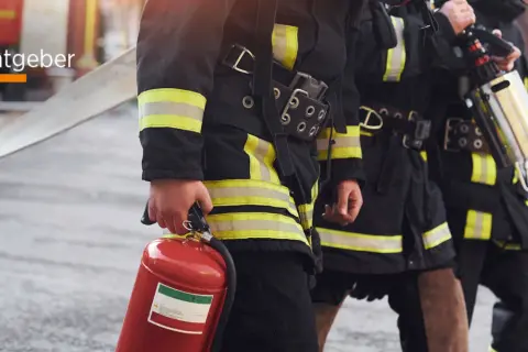 Feuerwehrleute mit Feuerlöscher und Schlauch. Informationen zu den berufsfeuerwehr voraussetzungen.