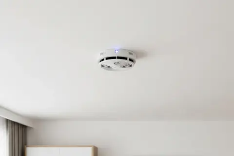 Rauchmelder an der Decke mit blauem Licht. Ein Fehlalarm durch zu hohe Luftfeuchtigkeit ist möglich.
