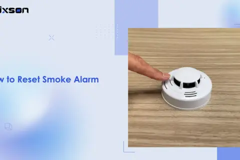 Ein Finger drückt auf einen weißen Rauchmelder, um einen Fehlalarm zu beenden.