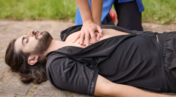 Hände auf die Mitte des Brustkorbs legen und kräftig drücken. So geht Herzdruckmassage, um Leben zu retten.