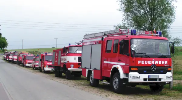 Reihe von roten Feuerwehrfahrzeugen, darunter 9 Fahrzeugtypen der Feuerwehr, bereit für den Einsatz.
