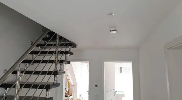 Moderner Flur mit Treppe und einem weißen rauchmelder an der Decke, der für Sicherheit sorgt.