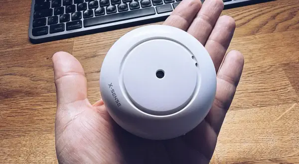 Rauchmelder von X-Sense in der Hand, bereit für die Integration in Home Assistant.