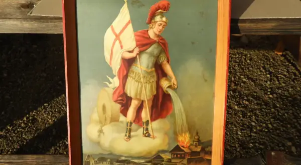 Gemälde zeigt den Heiligen Florian, der mit einem Krug Wasser ein brennendes Dorf löscht.
