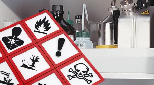Gefahrstofflager-Vorschriften: Symbole für giftig, entzündlich, ätzend und umweltgefährdend auf einem Regal mit Chemikalien.