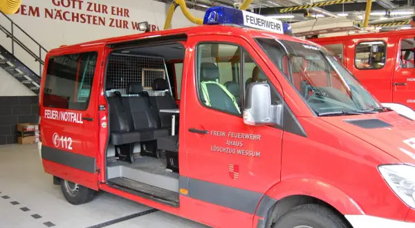 Rotes Feuerwehrauto mit Blaulicht, bereit für Einsätze und Veranstaltungen. Aufschrift "FEUERWEHR" und "FEUER/NOTFALL".