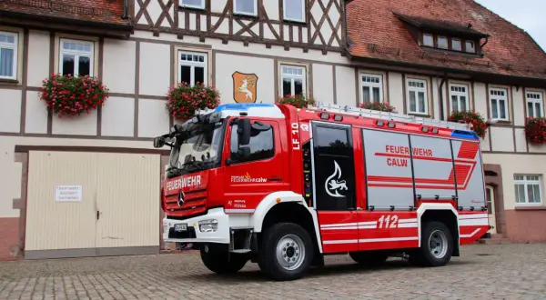 Rotes Löschfahrzeug LF 10 der Feuerwehr Calw, Abteilung Hirsau, vor einem Fachwerkhaus. Das Fahrzeug entspricht der DIN 14530-5.