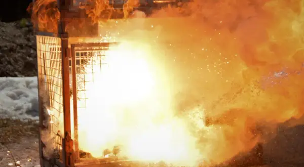 Ein Metallkäfig wird von einer gewaltigen Explosion aus Feuer und Rauch erfasst. Es ist beeindruckend zu sehen, dass metall brennen kann.