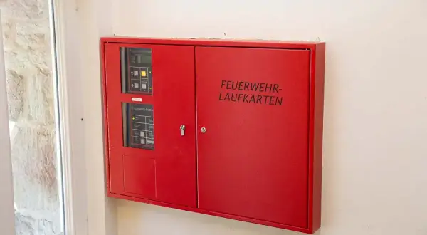 Rote Box mit der Aufschrift "FEUERWEHR-LAUFKARTEN" und Bedienfeldern für die Feuerwehr.