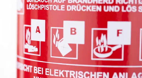 Symbole für Brandklasse A (feste Stoffe), B (flüssige Stoffe) und F (Fettbrände) auf rotem Feuerlöscher.