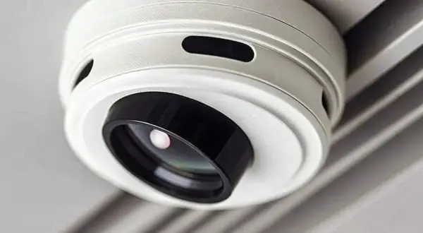 Ein weißer Rauchmelder mit integrierter Kamera, der unauffällig an der Decke montiert ist. Er hilft, Rauch zu erkennen und gleichzeitig die Umgebung zu überwachen.