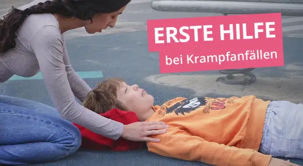 Erste Hilfe bei Krampfanfällen: Eine Frau kniet neben einem Kind, das auf dem Boden liegt.