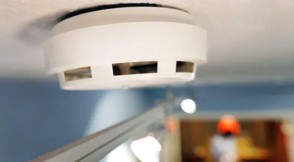 Ein weißer Rauchmelder an der Decke, wichtig für Mieter und Vermieter zur Sicherheit.