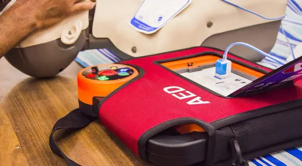 Defi-Herz-Training: Ein AED-Gerät und eine Übungspuppe für lebensrettende Maßnahmen.
